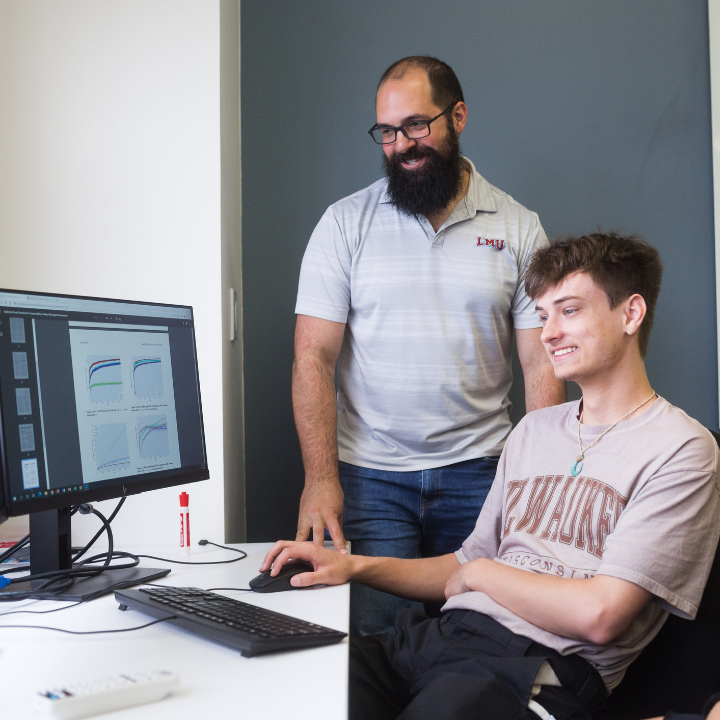 Professor and student looking at a computer